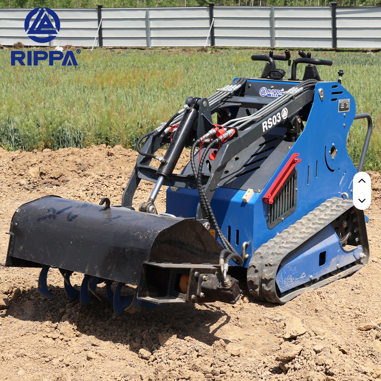 Blue Rippa RS03 gas skid steer with black tracked wheels and front soil auger attachment on dirt ground.