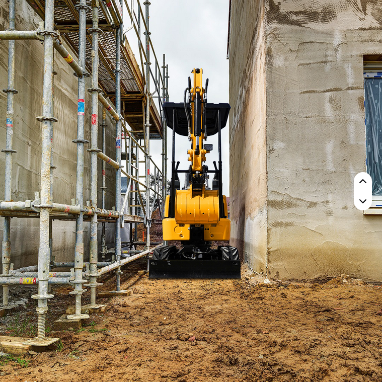 Yellow and black Rippa R319 mini excavator with hydraulic thumb working between building and scaffolding on dirt.