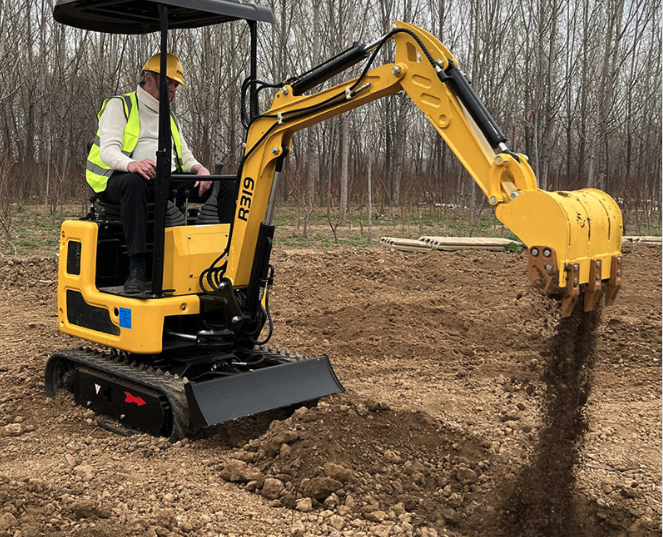Yellow Rippa R319 mini excavator with hydraulic thumb digging soil on construction site.